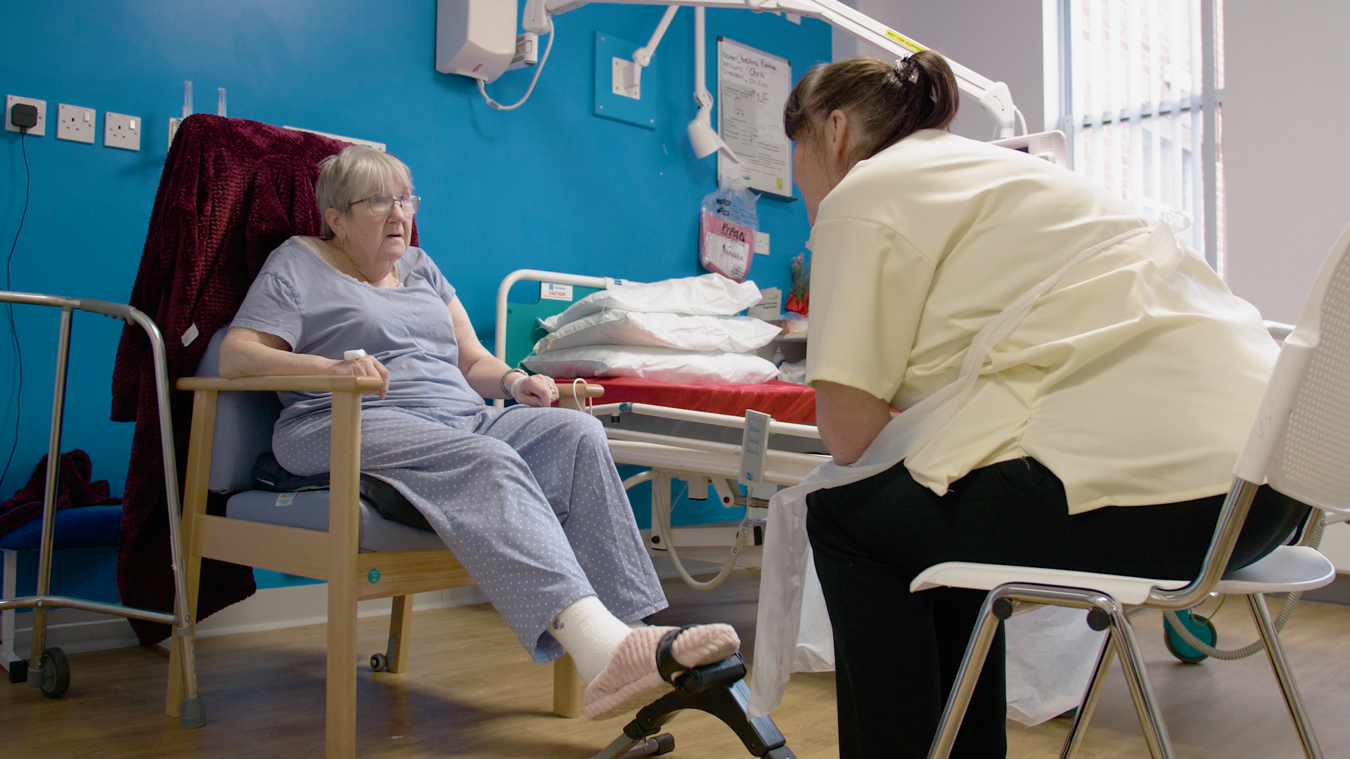 A hospital patient on a ward with a staff member